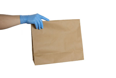 Midsection of woman holding paper against white background