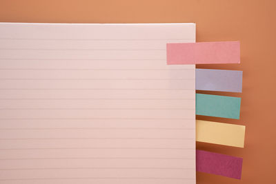 Directly above of diary with adhesive notes on brown background