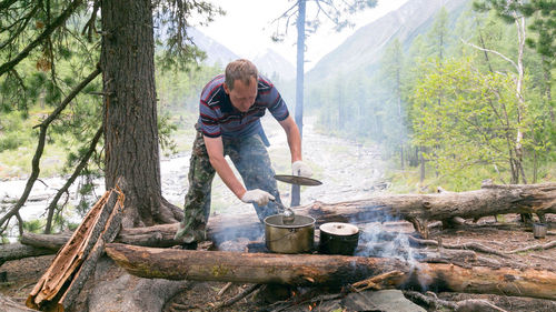Man cooking food in forest 