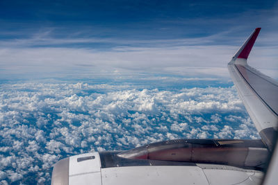 Airplane flying over cloudscape against sky