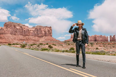 Man standing on road against rock formation