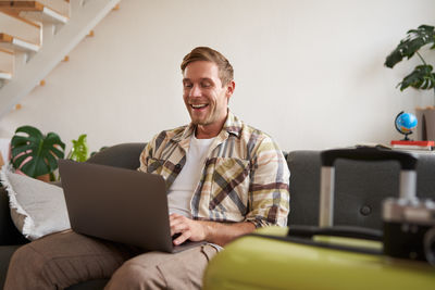 Young man using laptop while sitting at home