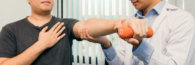 Midsection of doctor examining patient at clinic