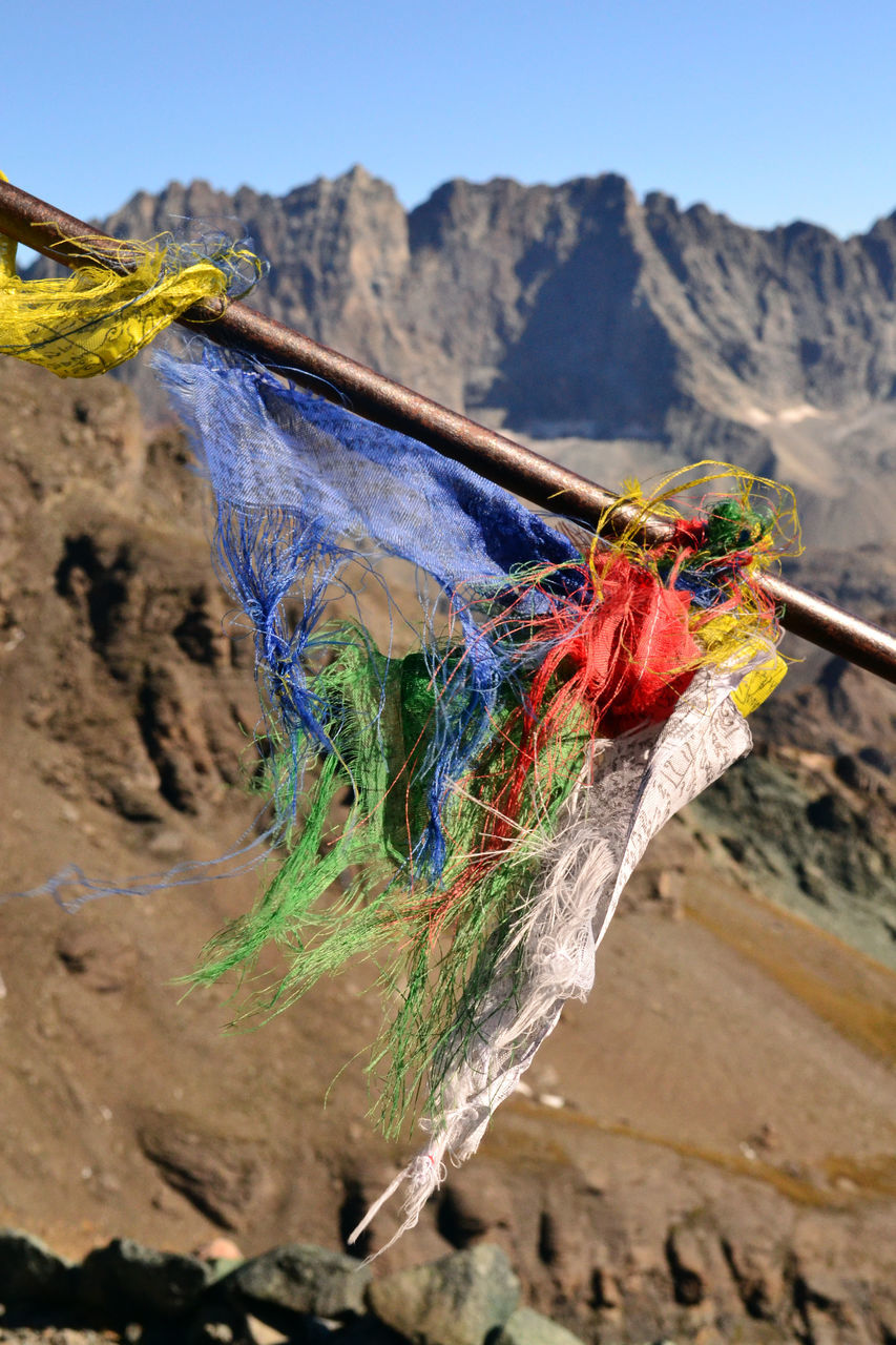 CLOSE-UP OF MULTI COLORED HANGING ON ROPE