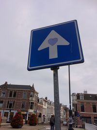 Low angle view of road sign against blue sky