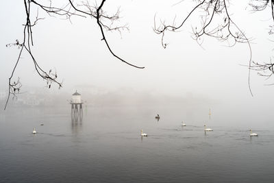 Scenic view of lake against sky during foggy weather