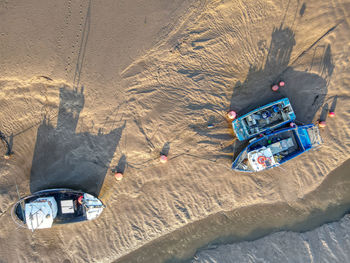 Overhead drone image of boats moored in muddy harbour