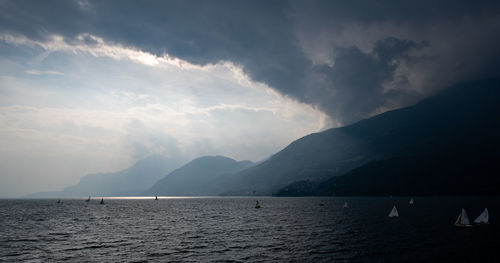 Scenic view of sea and mountains against sky