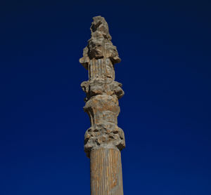 Low angle view of statue against blue sky