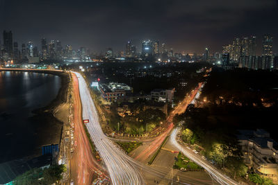 High angle view of illuminated highway amidst buildings in city at night