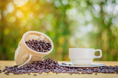 Close-up of coffee cup and beans on table
