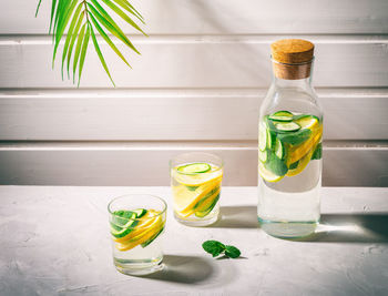 Sassy water for detox infused with lemon, cucumber and mint in glasses on white background. 