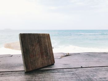 Wooden posts on beach against sky