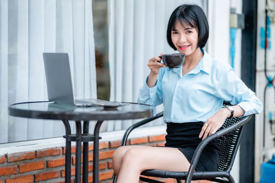 Young woman using mobile phone in cafe
