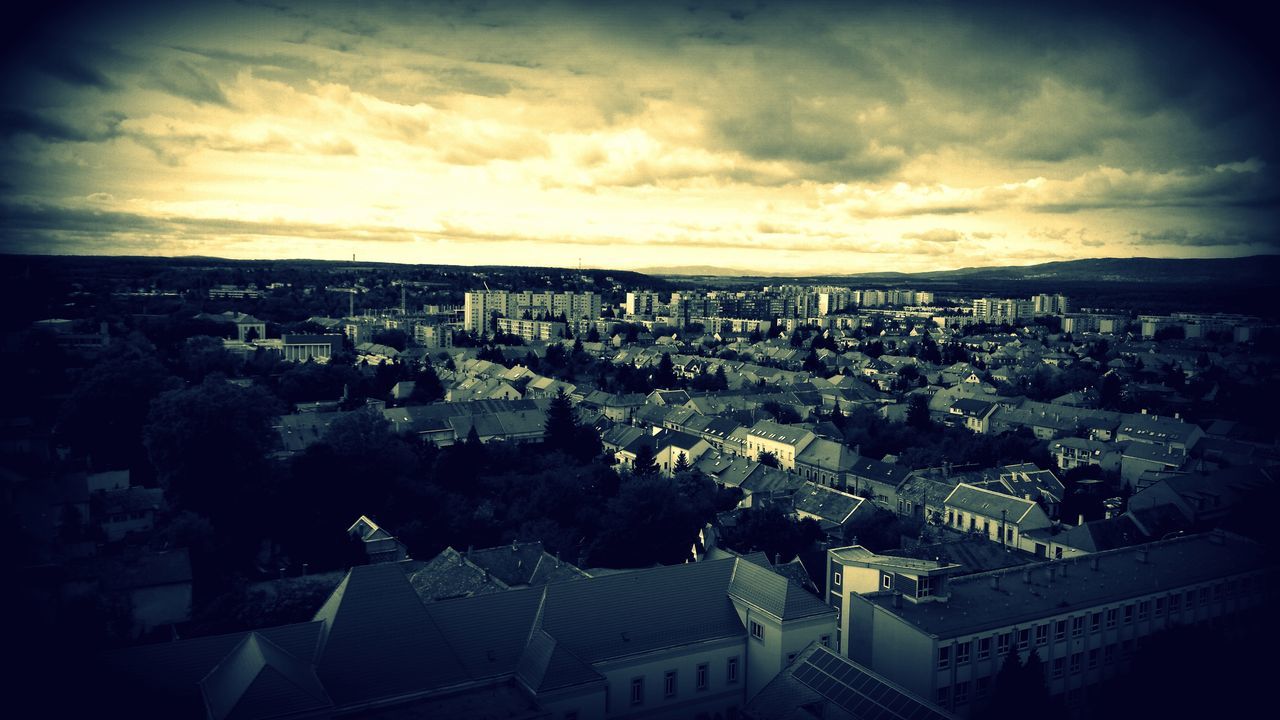 HIGH ANGLE VIEW OF RESIDENTIAL DISTRICT AGAINST CLOUDY SKY