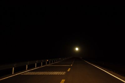 Empty road against sky at night