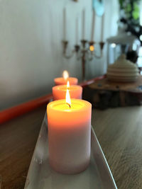 Close-up of lit tea light candles on table