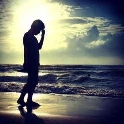 Silhouette of people on beach at sunset