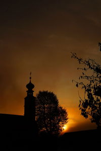 Silhouette of lighthouse against sky during sunset