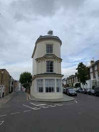 Road by building against sky in city