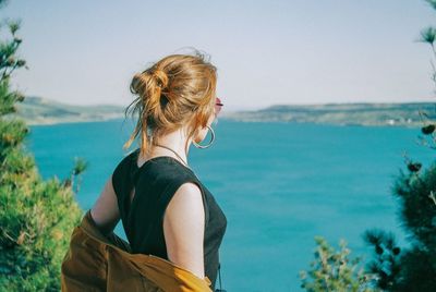 Rear view of woman looking at sea against sky