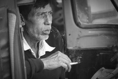 Man smoking while sitting jinrikisha