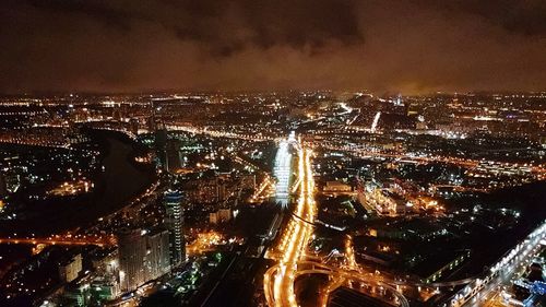 High angle view of city lit up at night