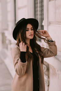 Portrait of young woman wearing hat standing outdoors