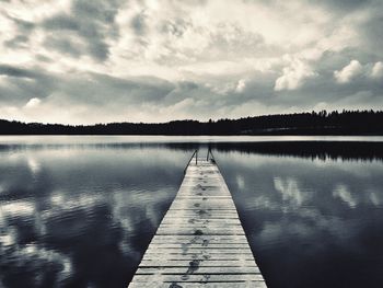 Pier over lake against sky during sunset