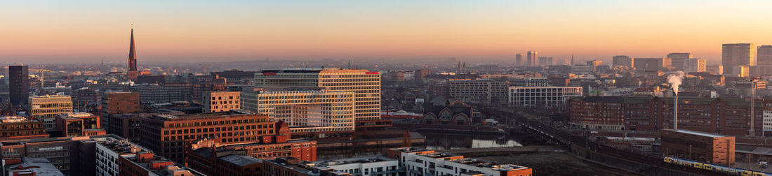 Aerial view of buildings in city during sunset