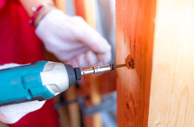 Carpenter and screwdriver hand tool. a skilled worker set to work drilling and installing wooden fix