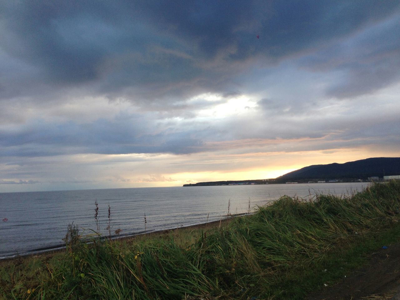 sky, sea, water, tranquil scene, scenics, tranquility, horizon over water, beauty in nature, beach, cloud - sky, shore, grass, nature, sunset, cloud, cloudy, idyllic, coastline, non-urban scene, outdoors