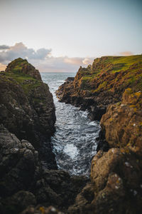 Rocks on sea shore against sky