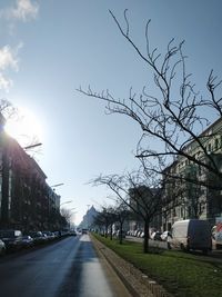 Cars on road against sky in city