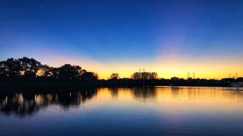 Scenic view of lake against sky at sunset