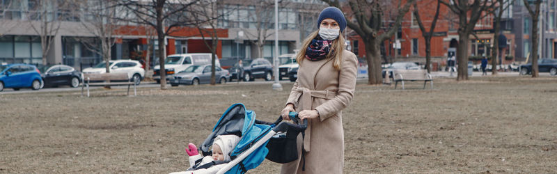 Portrait of mother with baby standing outdoors