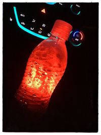 Close-up of illuminated lighting equipment against black background