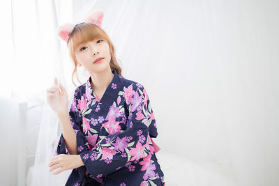 Portrait of woman standing against wall