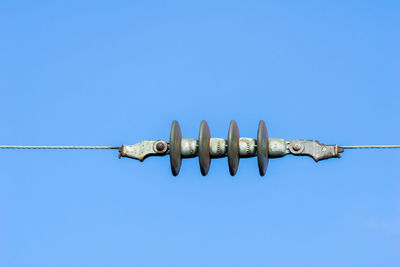 Low angle view of wind turbine against clear blue sky