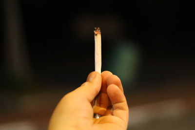 Close-up of hand holding cigarette