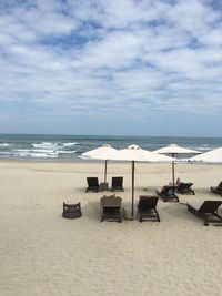 Chairs on beach against sky