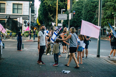 Group of people walking on sidewalk in city