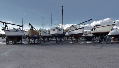 Boats on trailer against sky at harbor