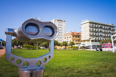 Built structure on field against buildings in city