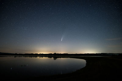 Scenic view of lake against sky at night neowise comet