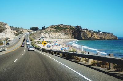 Empty road against clear blue sky