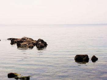 Rocks in sea against sky