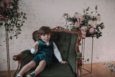 Portrait of girl sitting on seat at home
