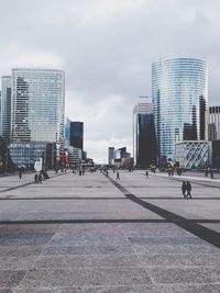 Buildings in city against cloudy sky