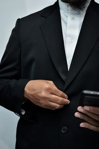 Midsection of man holding mobile phone